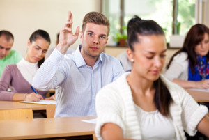 31582249 - student male raising his hand in university class