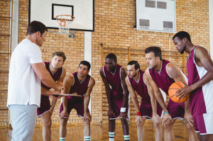 Coach explaining game plan to basketball players